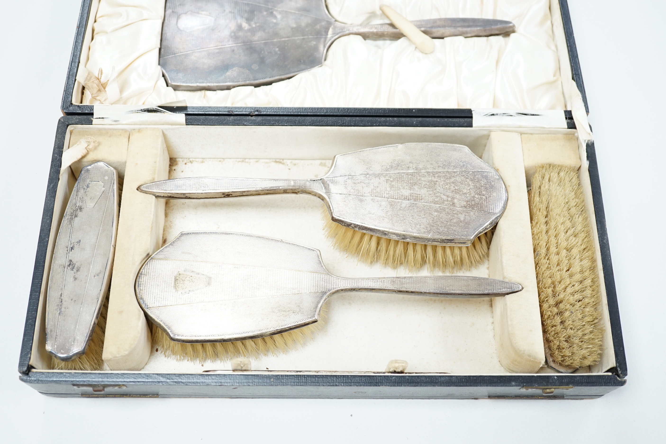 A 1930's cased engine turned silver mounted six piece mirror and brush set, by William Neale & Son Ltd.